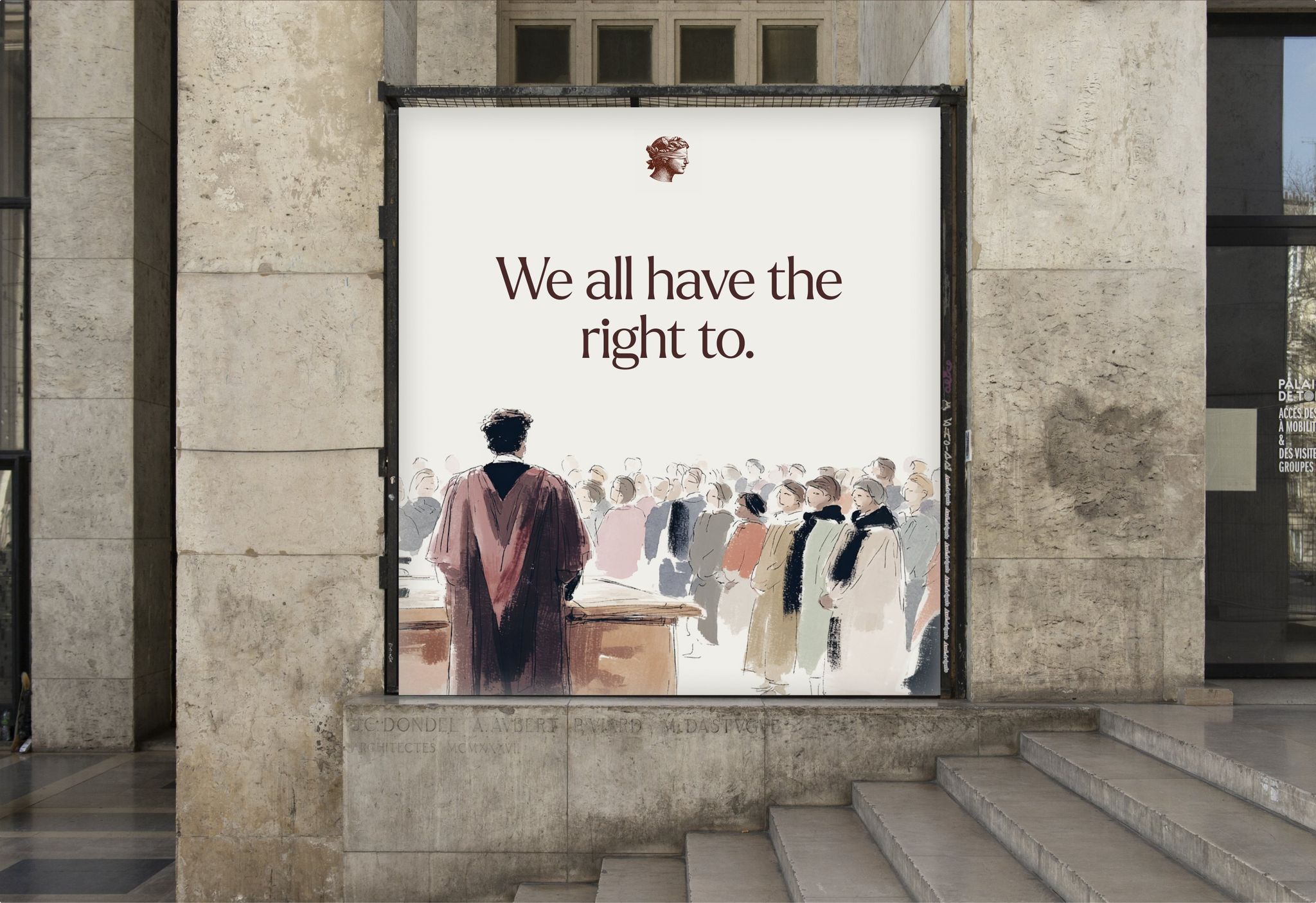 Causélis poster “We all have the right to.” at the entrance of a stone courthouse