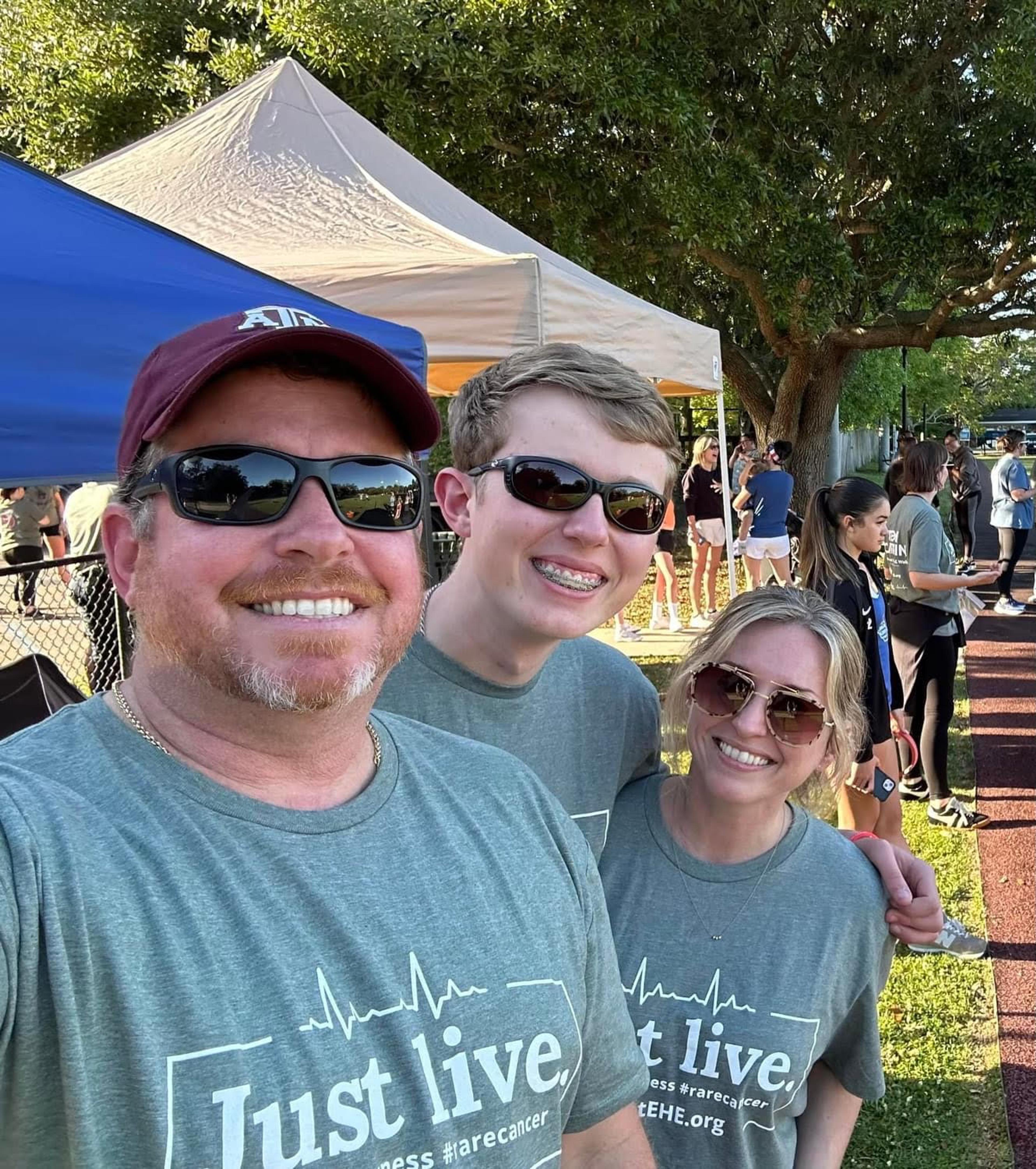 A Family in matching tshirts smiles for a selfie