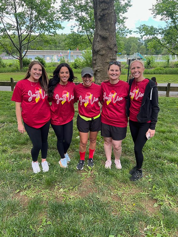 A group of woman pose for a photo in their red team shirts