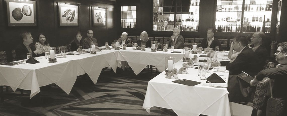 A group of people sitting around a large wrap around table