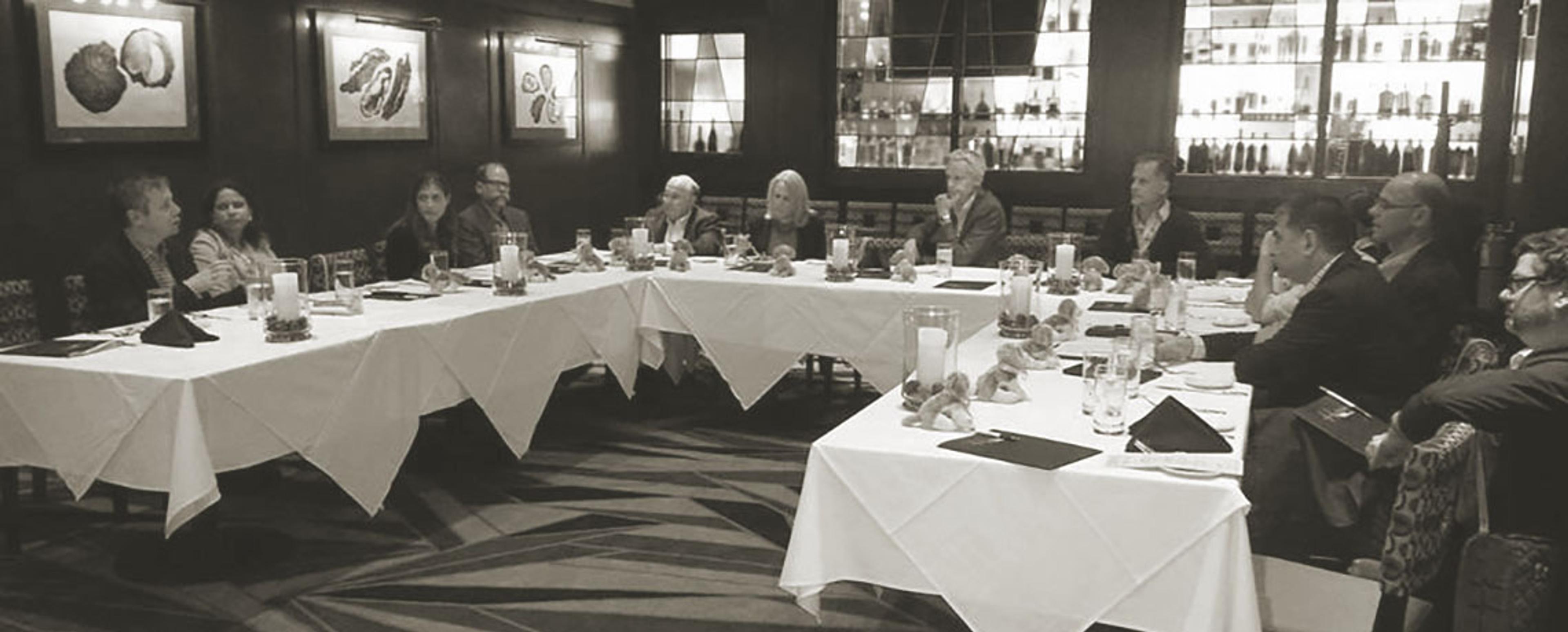 A group of people sitting around a large wrap around table