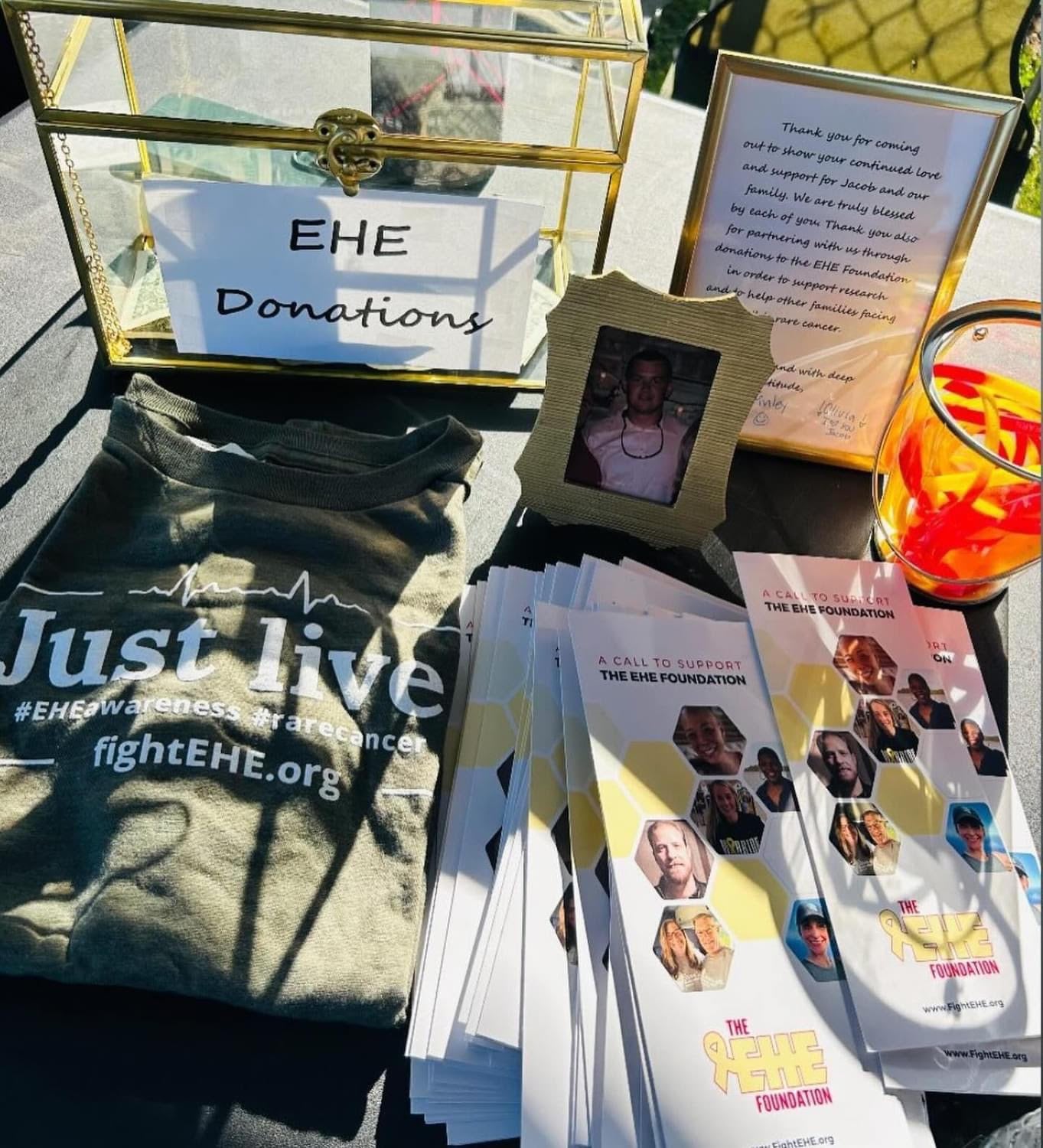 A Memorial for someone who passed, that includes a donations box, tshirt, and pamphlets.
