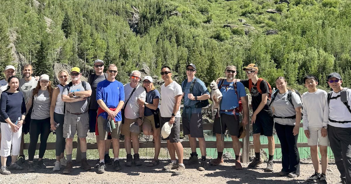 group of people standing in front of trees