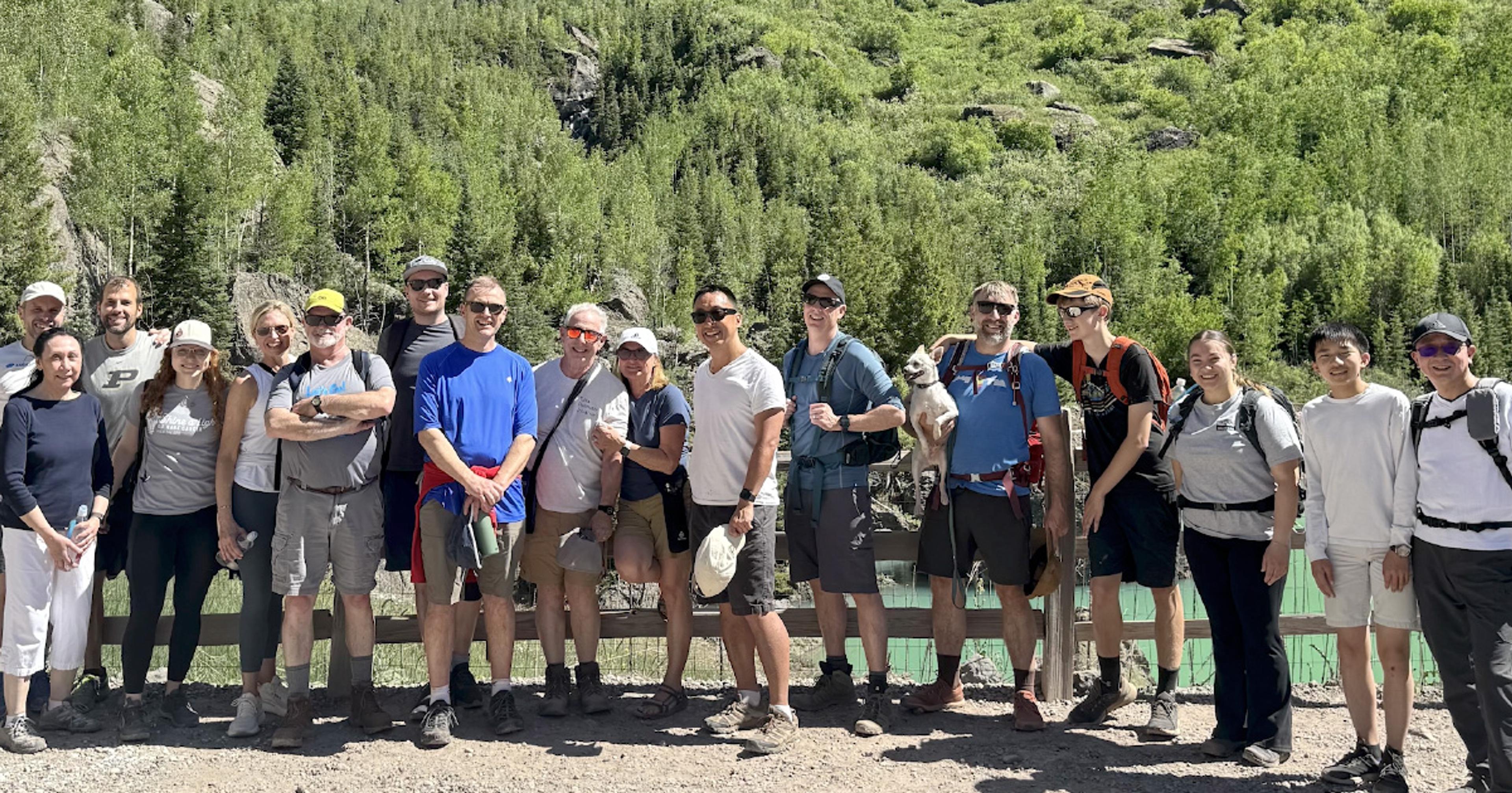 group of people standing in front of trees