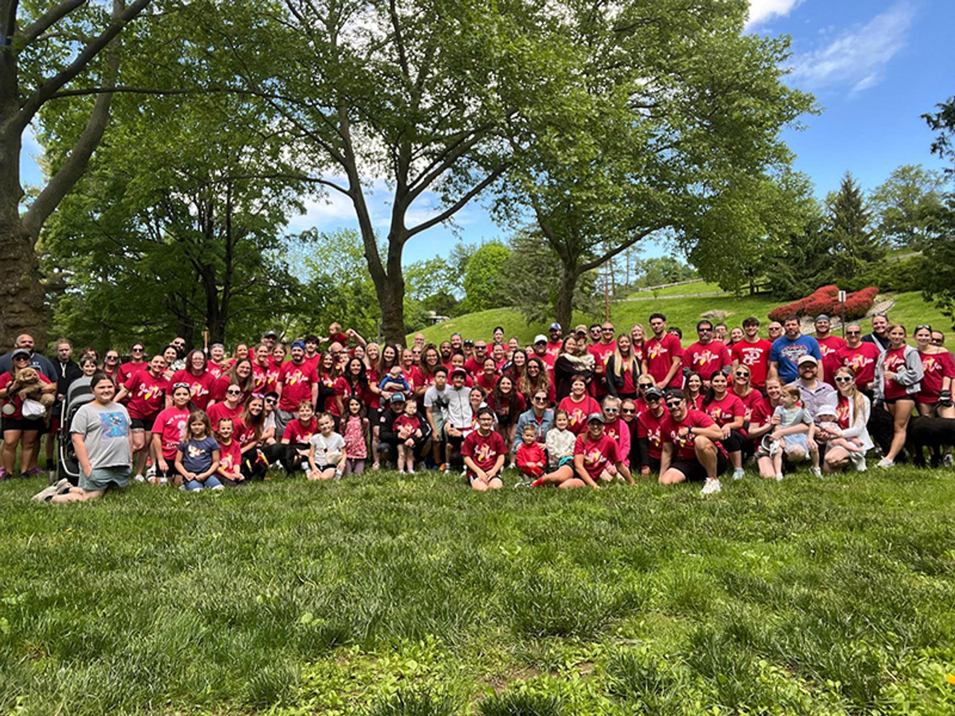 A large group of people take photo in their red team shirts