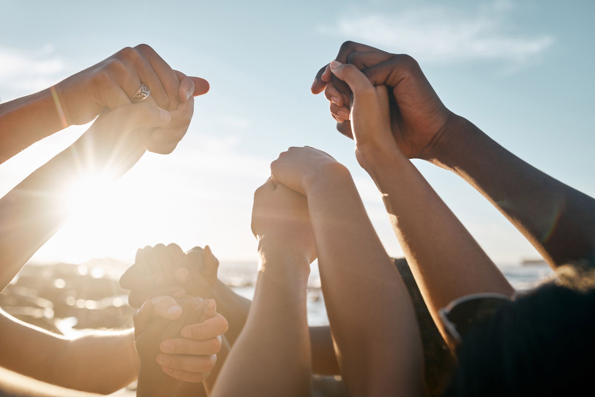 A group of people with their arms in the air holding hands.