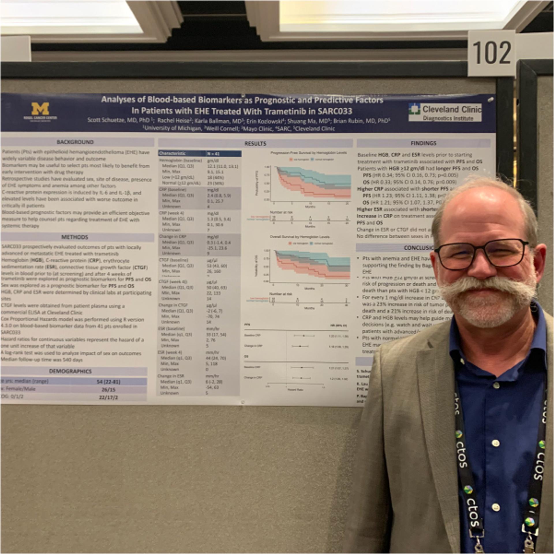 Dr. Scott Schuetze, University of Michigan, standing next to a print out of his work.