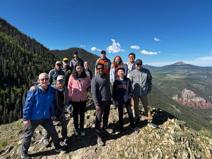 The crew standing in front of the mountain range.