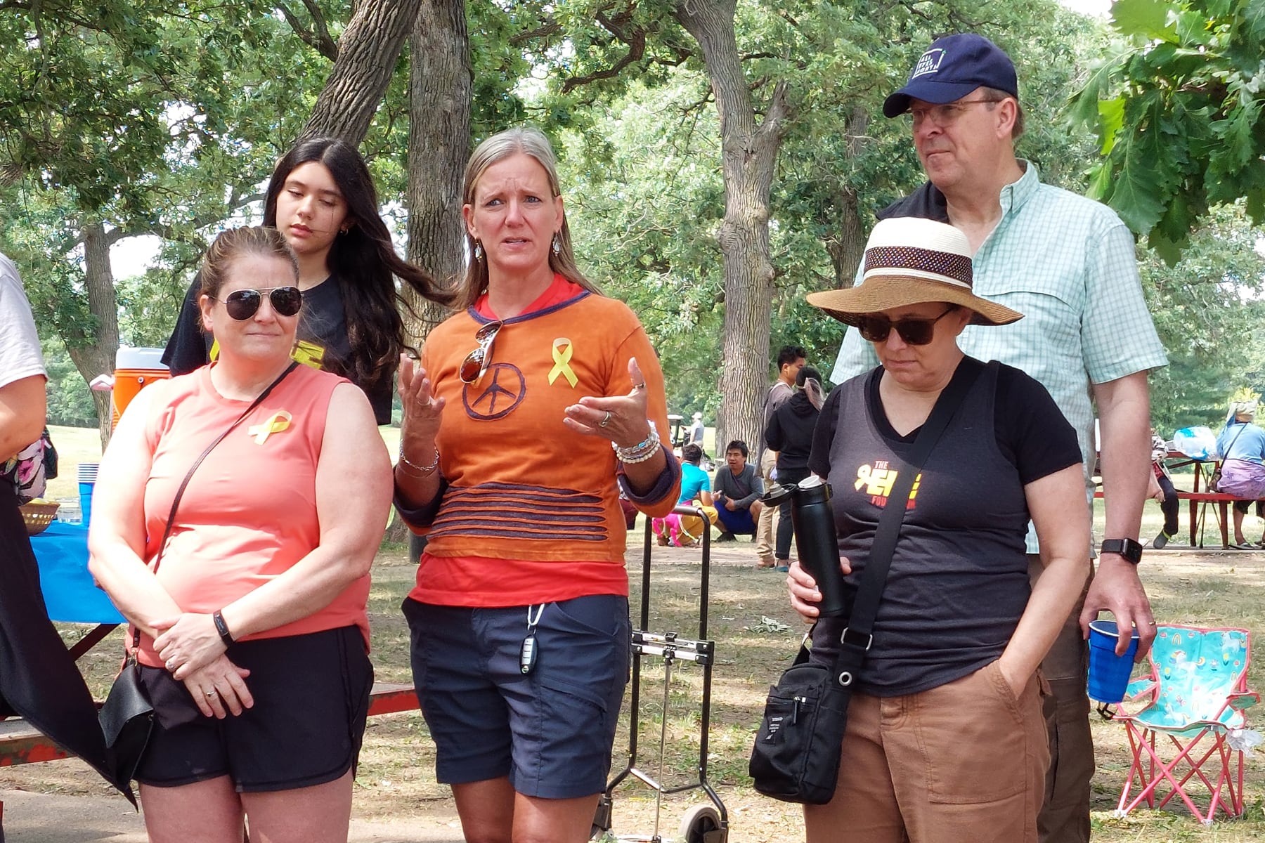 A crew of run walkers with a woman in an orange hoody explaining something to the group