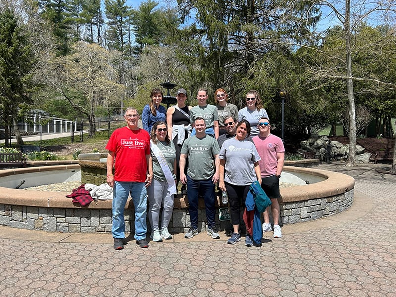 A group of people come together for a photo by the water fountain