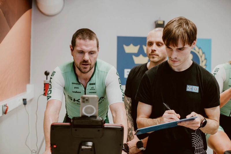 a group of men are riding exercise bikes in a gym .