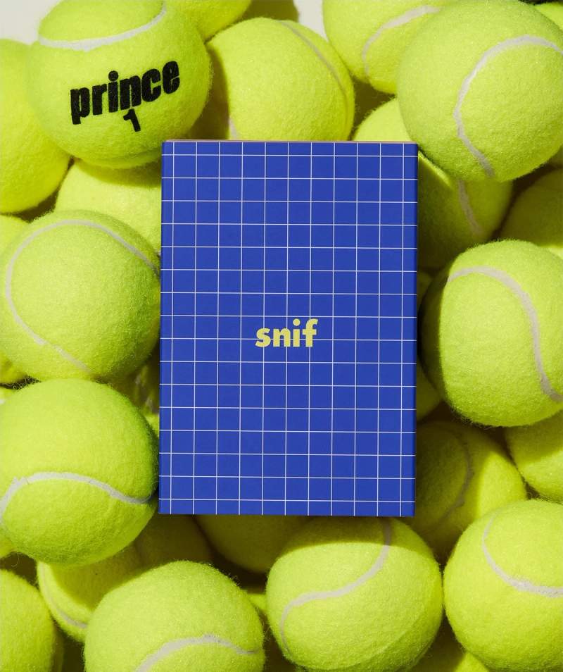 a pile of tennis balls with a blue cover that says snif