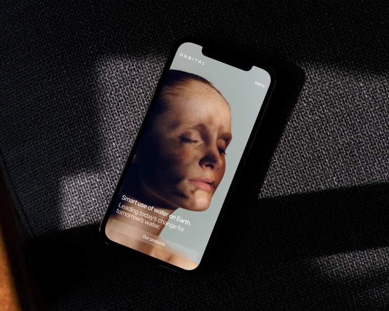a black cell phone with a picture of a woman 's face on the screen .