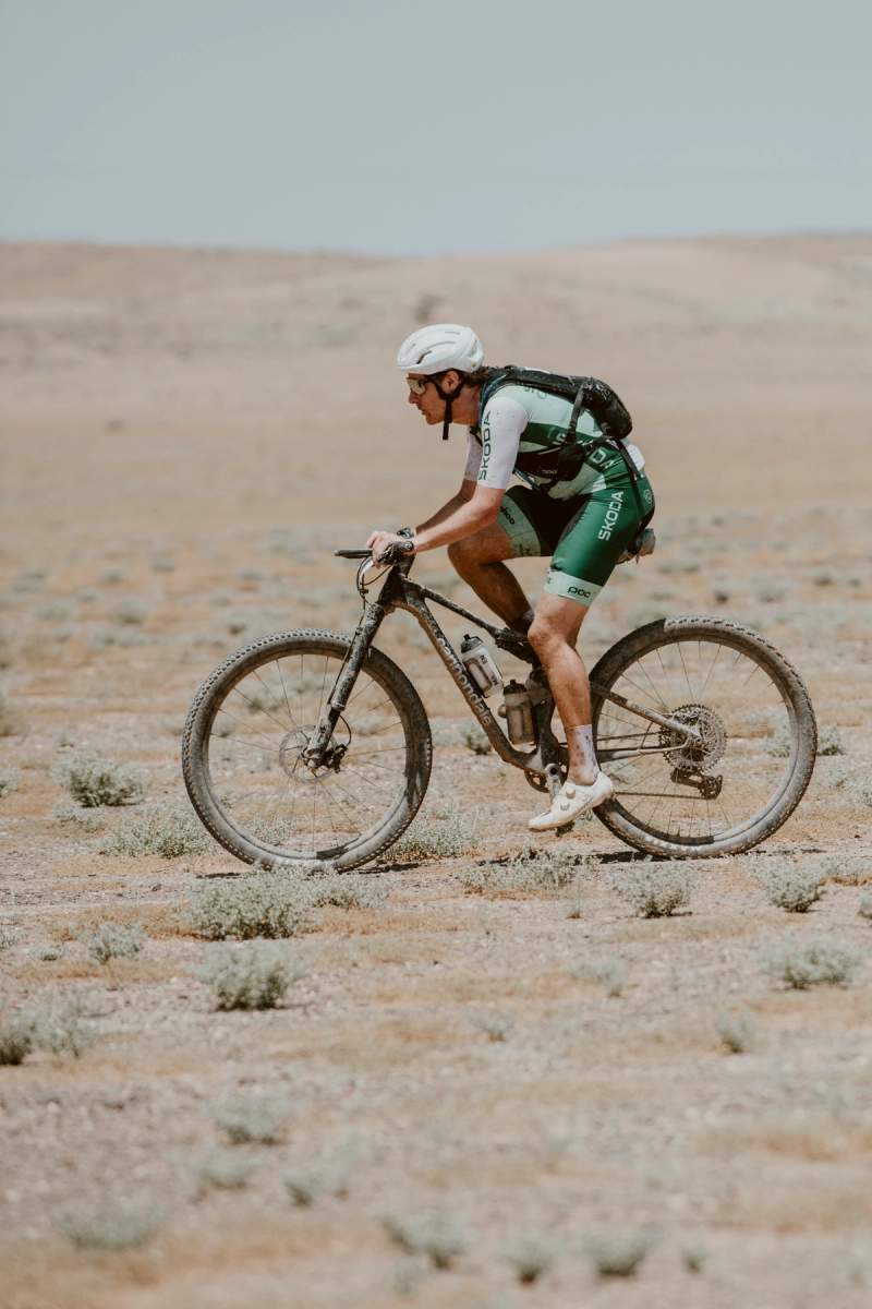 a man is riding a bike in the desert .