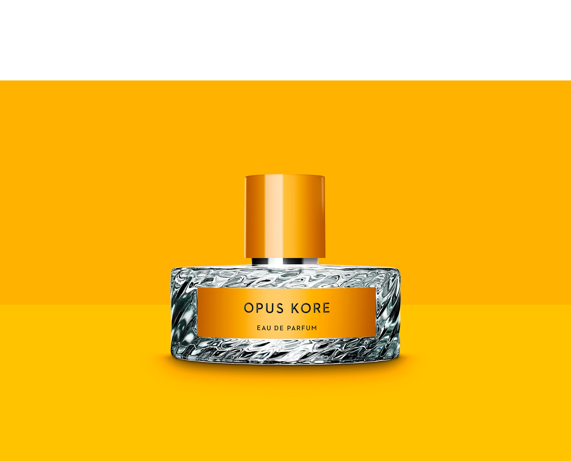 Opus Kore perfume bottle with a textured glass base, orange label, and orange cap, on an orange background.