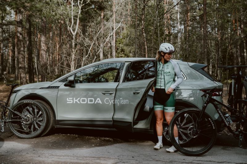 a woman is getting out of a skoda car with a bicycle .