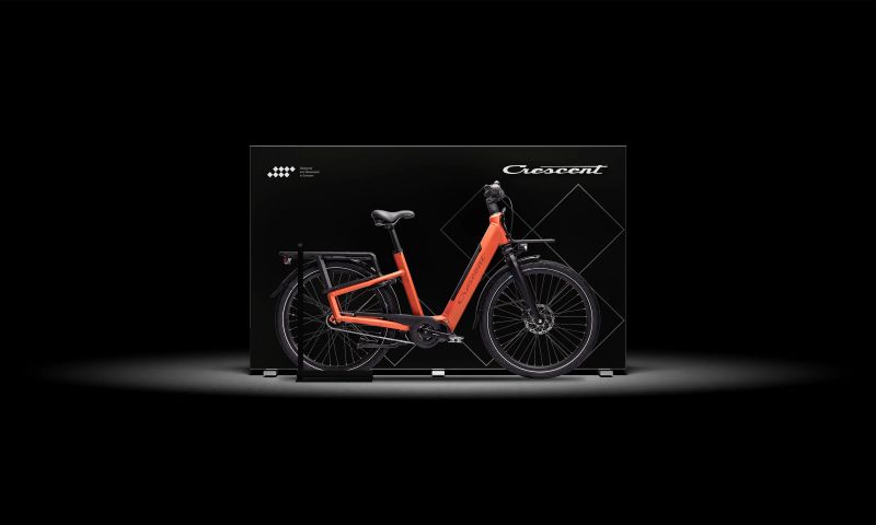 a red bicycle is sitting on top of a black box on a black background .