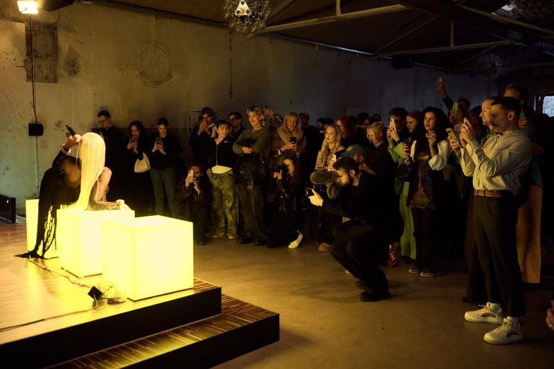 a group of people are standing around a stage in a dark room .