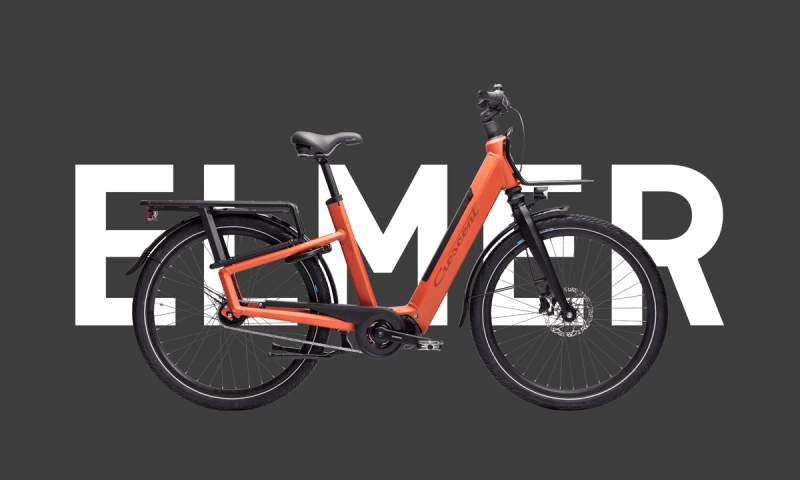 a red electric bike is sitting on top of a black background .