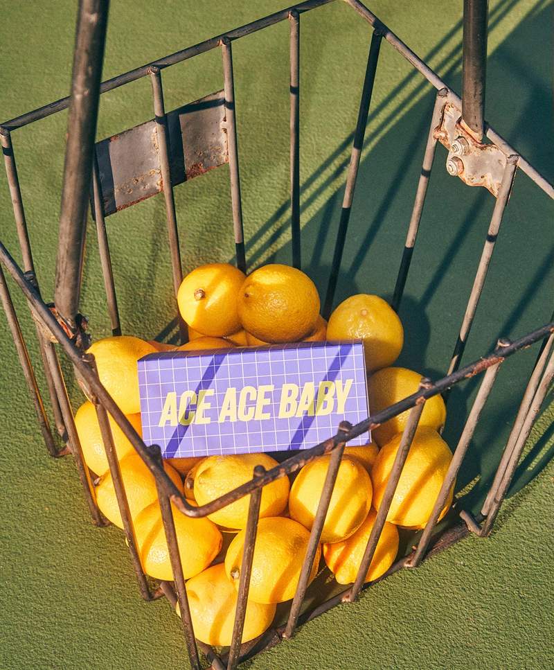 a basket of lemons with a sign that says ace ace baby