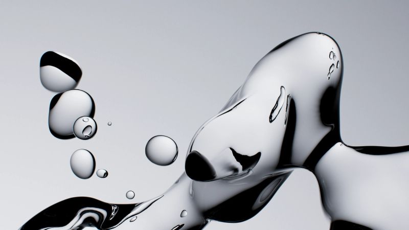 Clear water droplets and an abstract fluid form against a light background.