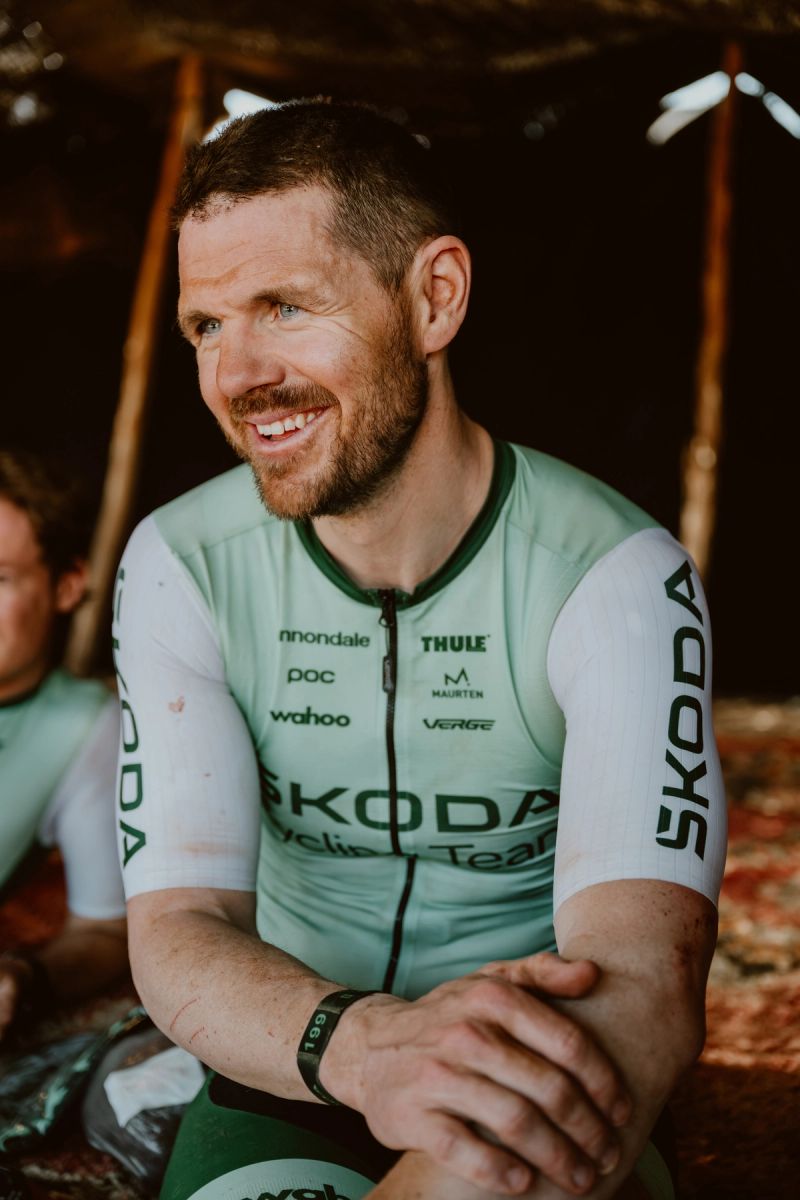 a man wearing a green and white skoda jersey