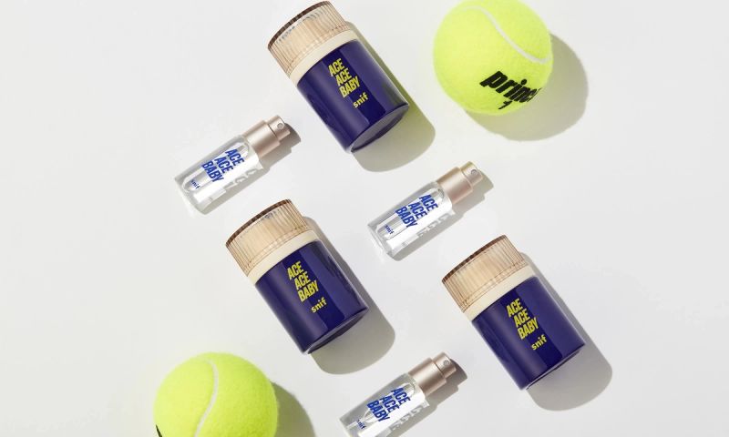 a tennis ball and bottles of ace ace baby cologne on a white surface .
