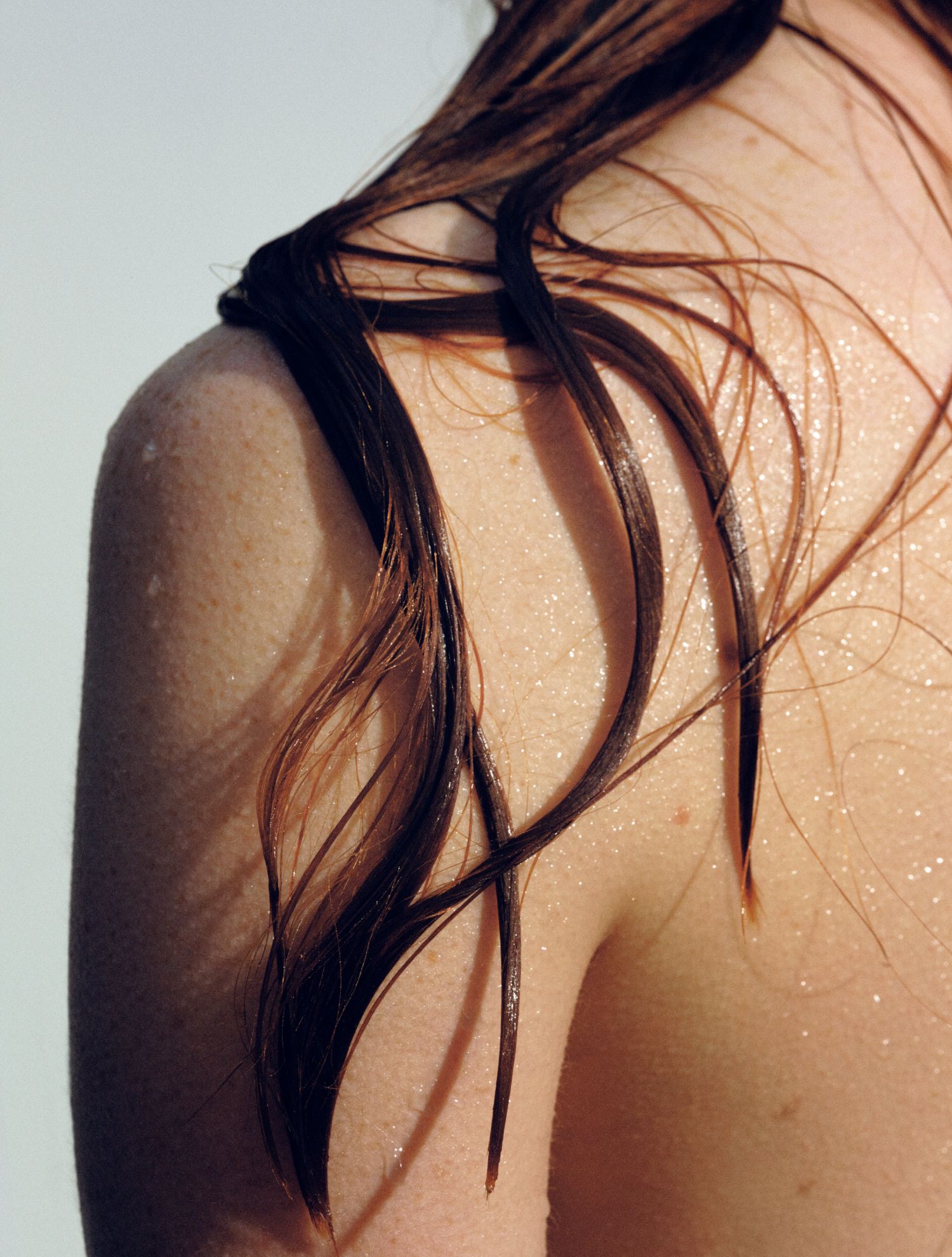 A close up of a woman 's back with wet hair