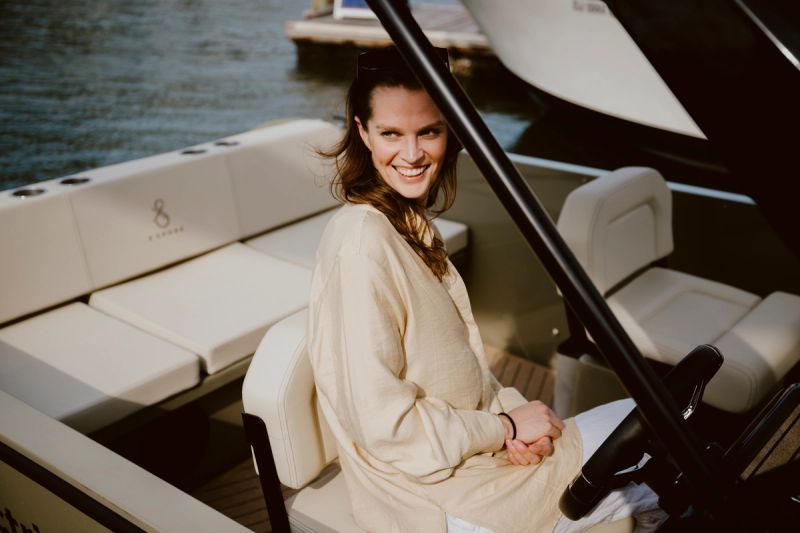 a woman is sitting in the driver 's seat of a boat .