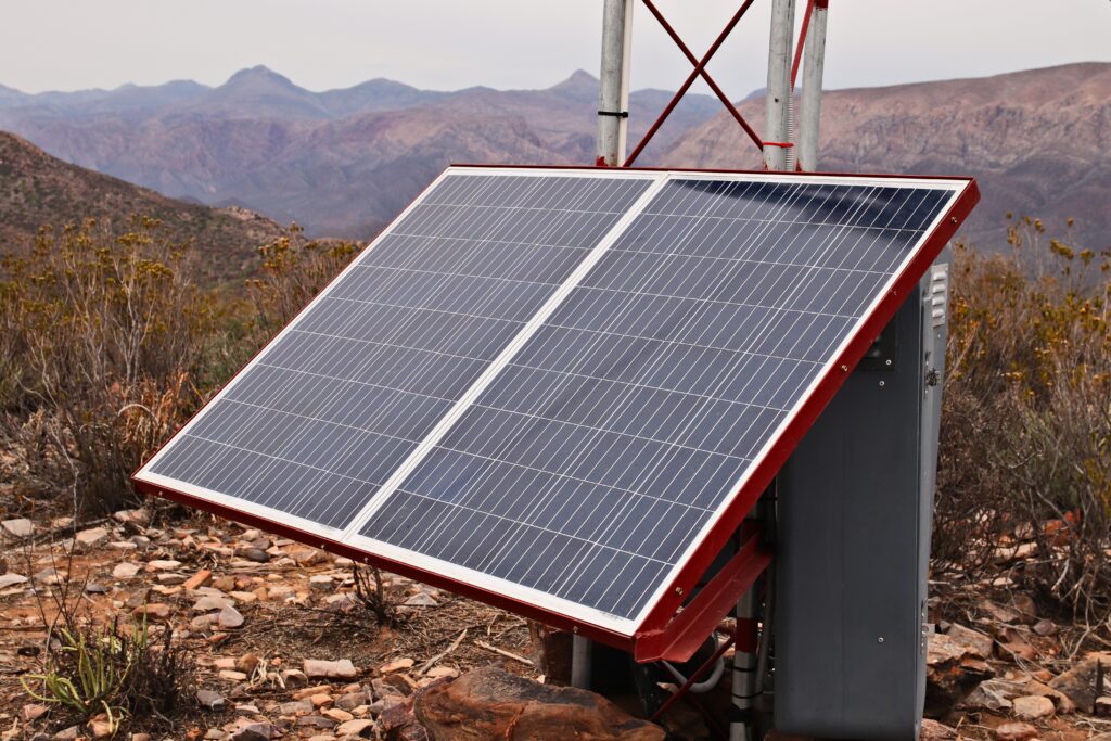 Standalone solar panel mounted on a pole in rocky hills