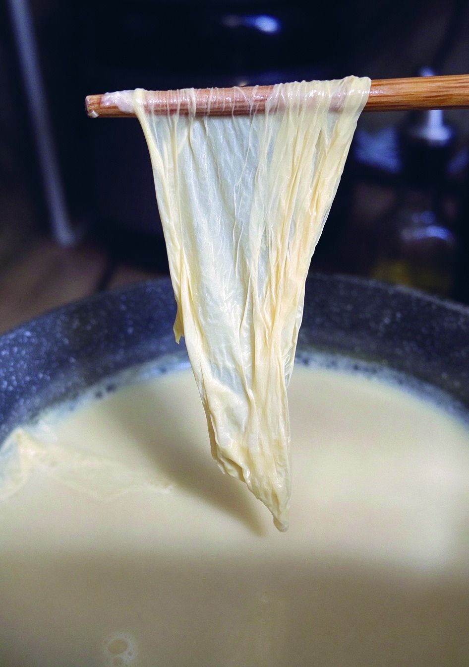 Lifting fresh tofu skin from warm soy milk