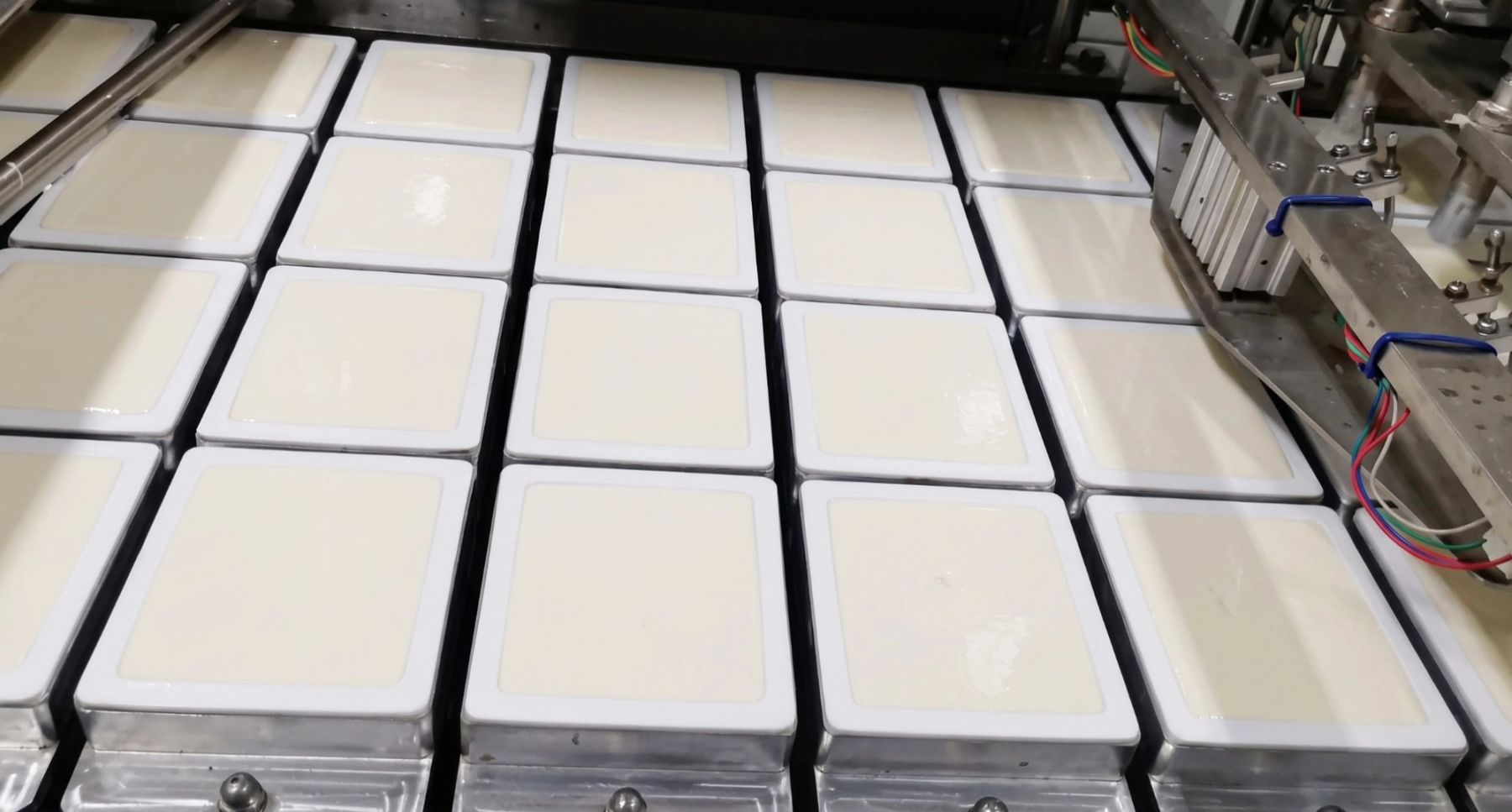 Silken tofu making and packaging. Courtesy of Kangdeli.