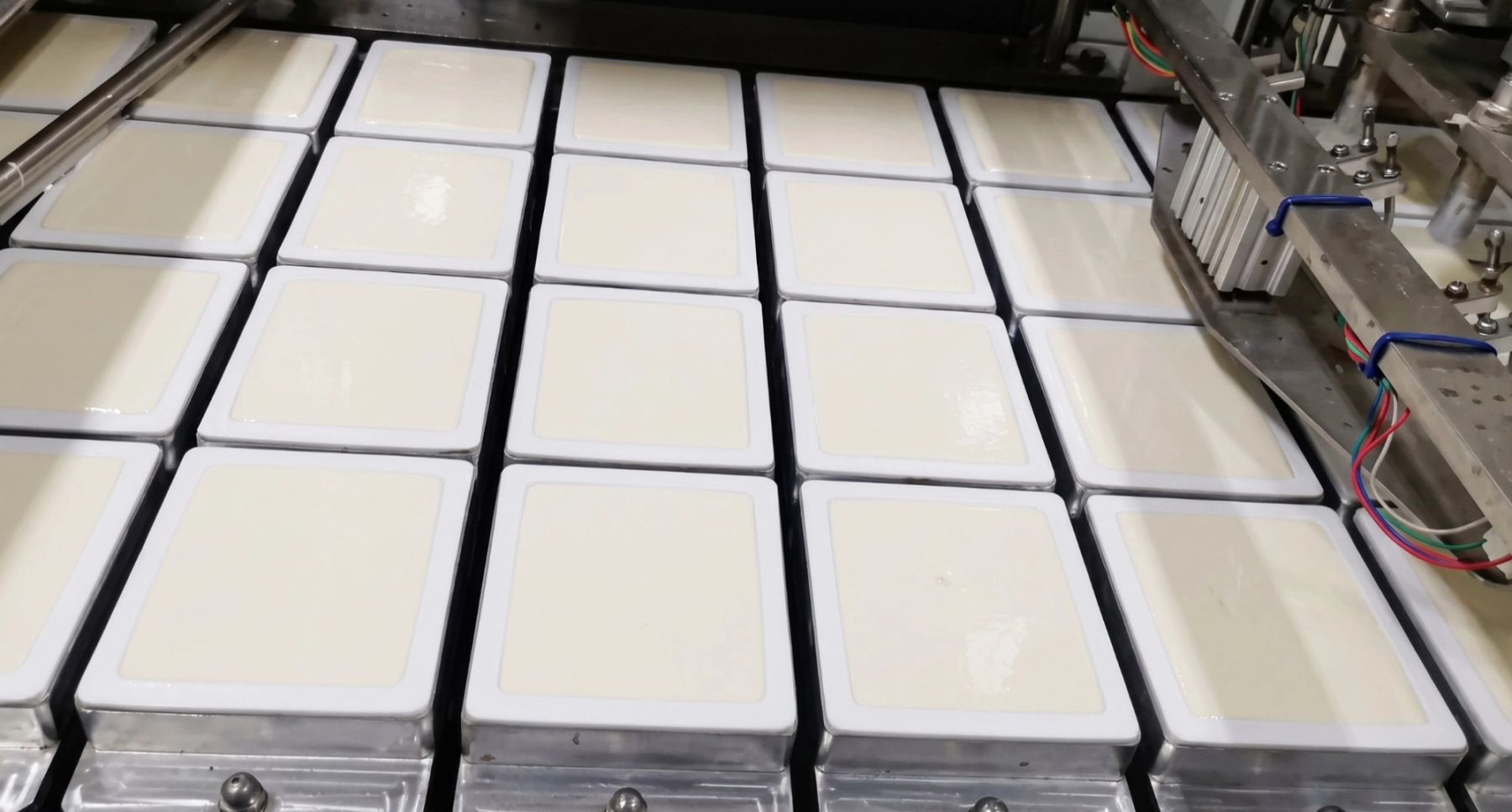 Silken tofu making and packaging. Courtesy of Kangdeli.