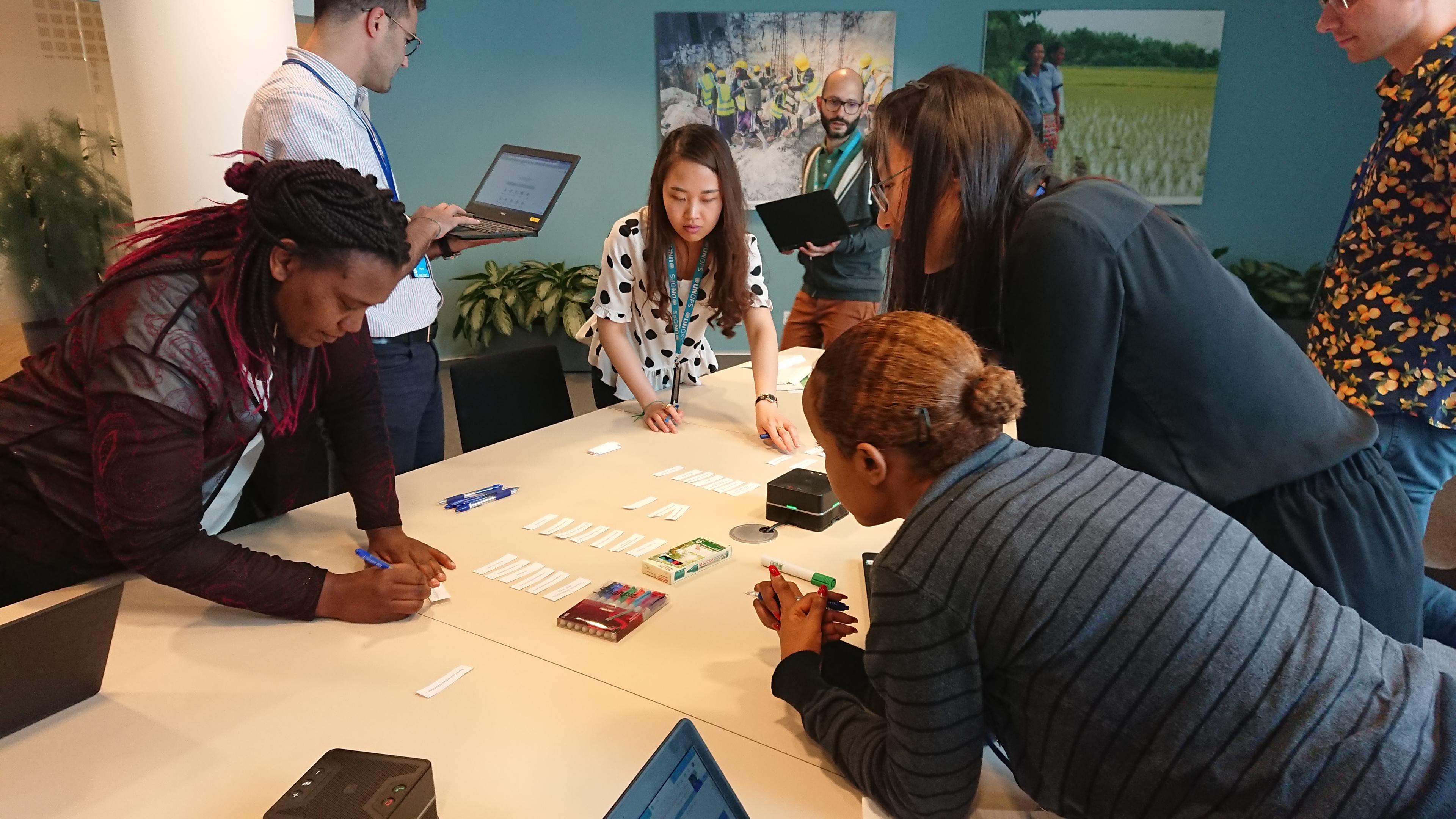 People gathered around a table looking at labels.