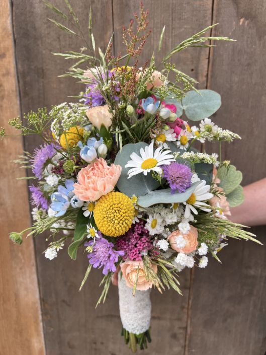 Natürlicher Hochzeitsstrauß mit saisonalen Wiesenblumen und viel frischem Grün