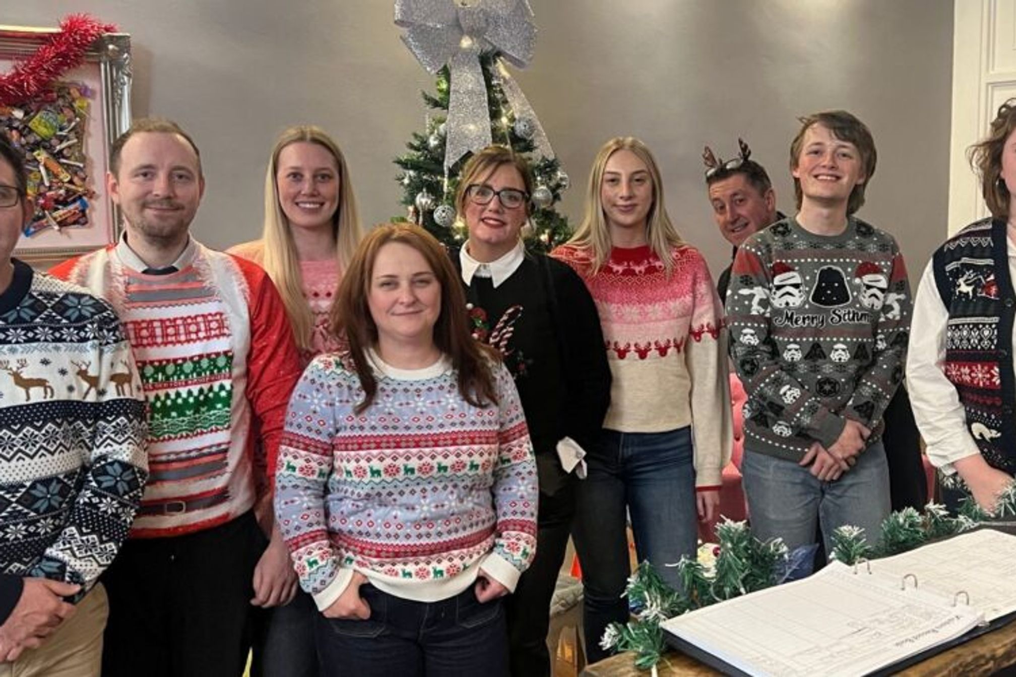 A group of people wearing Christmas themed jumpers.