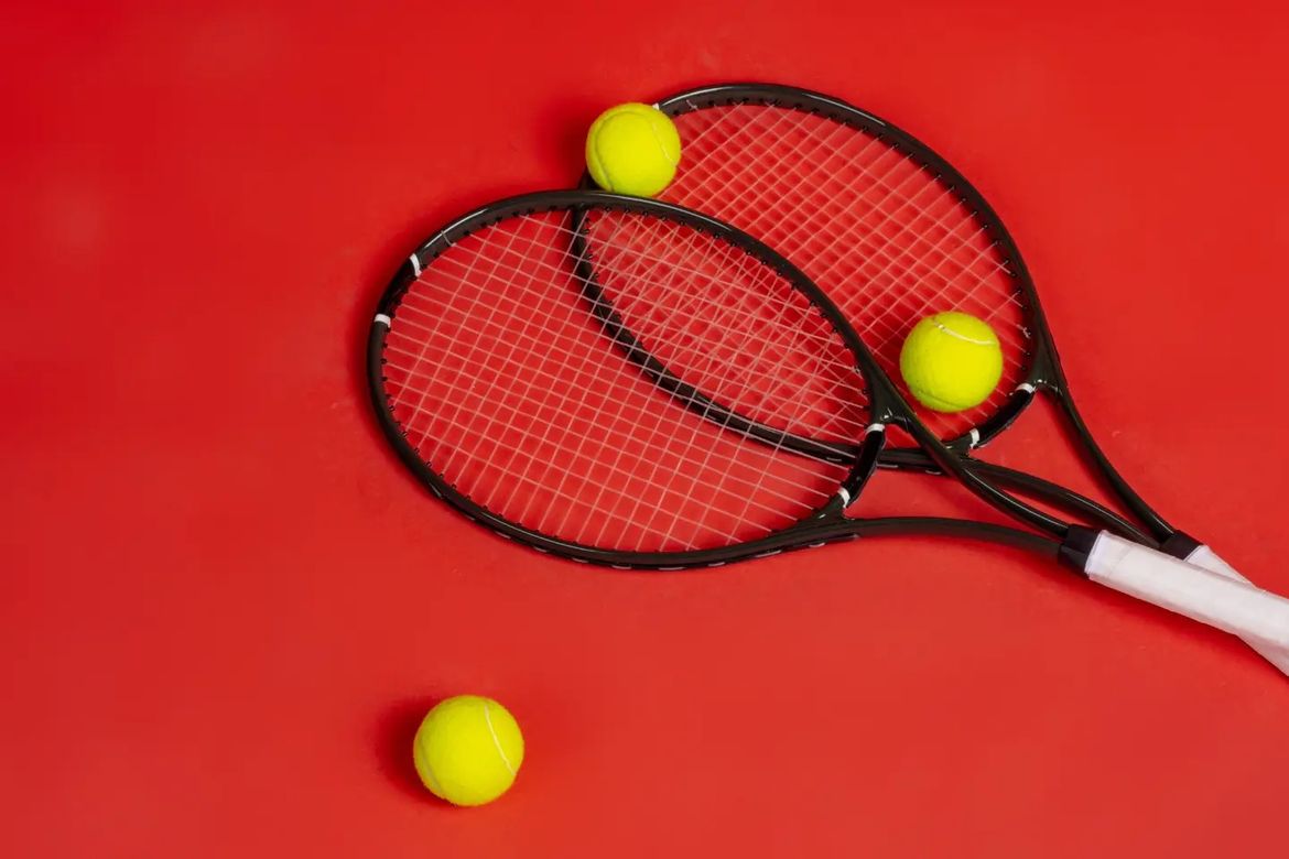 Two tennis rackets and three tennis balls on a red background