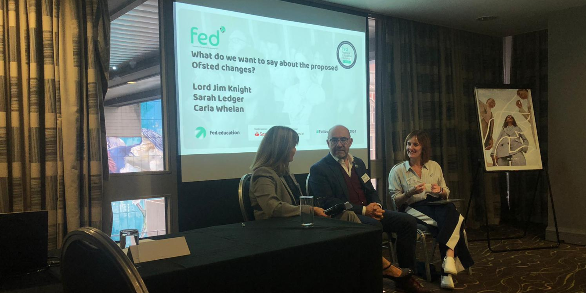 A panel sitting together as presenters at a conference.