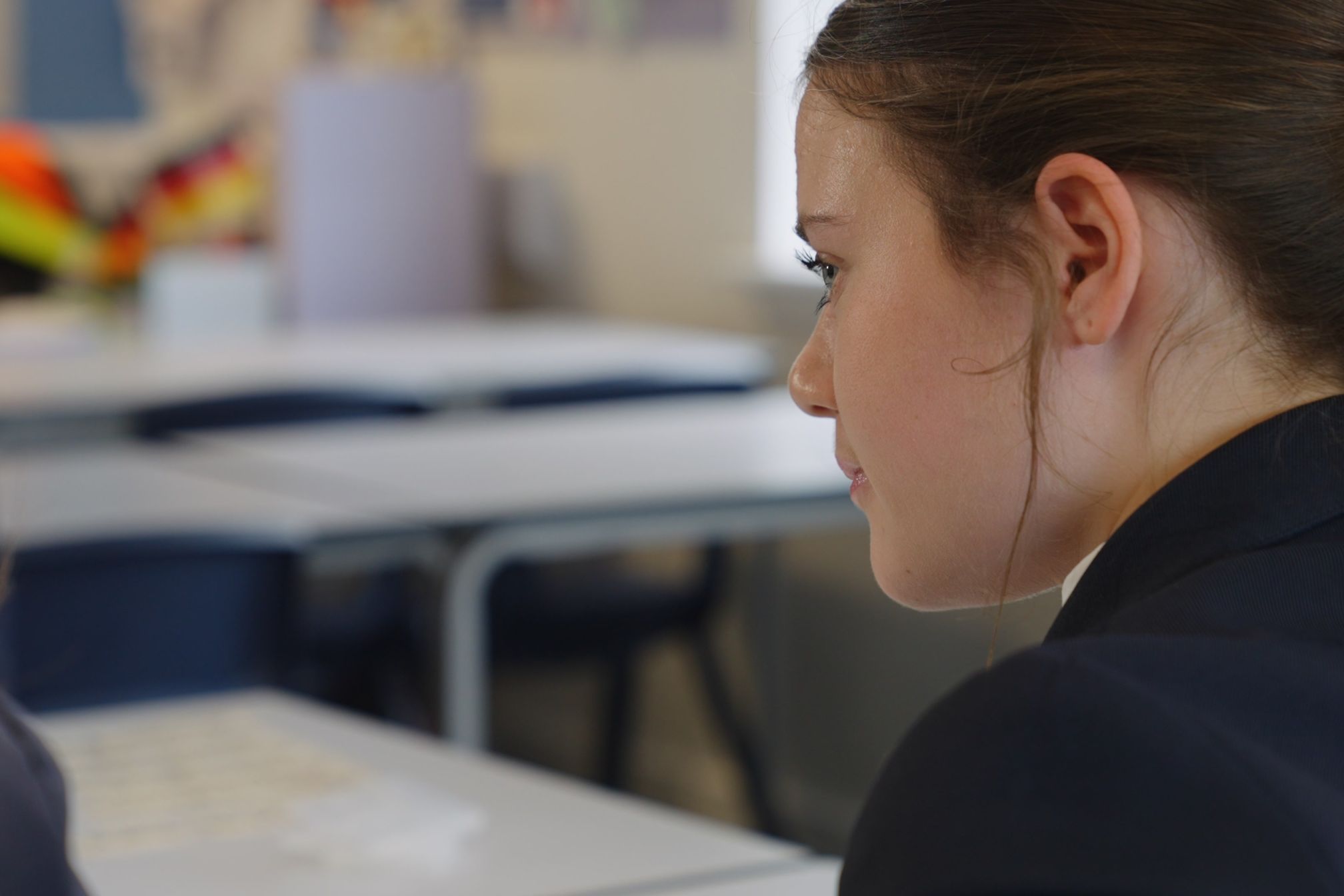 Child sat in a classroom.