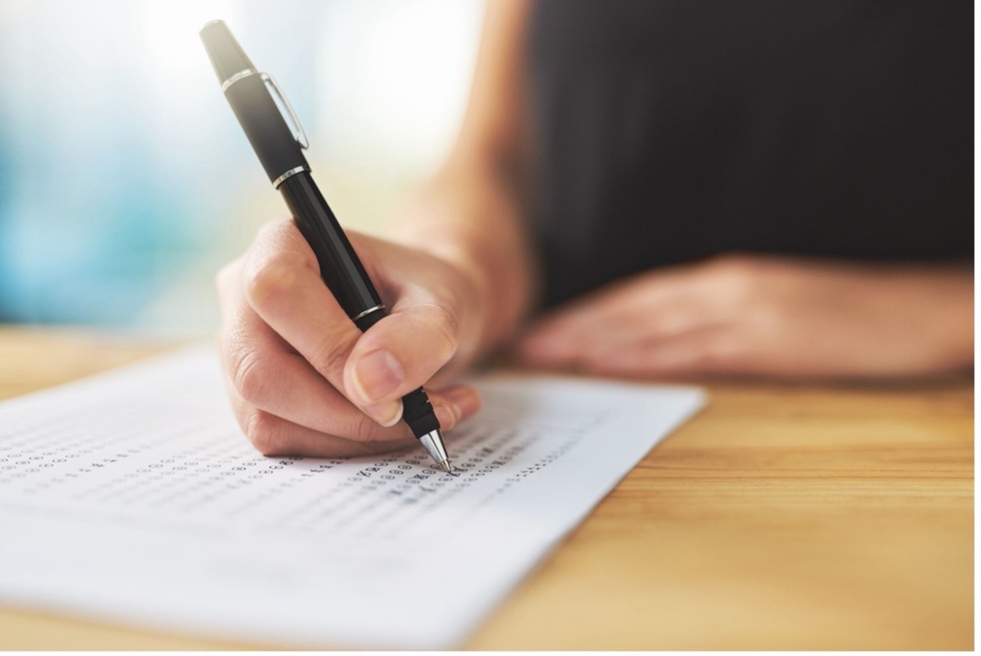 A person holding a pen to mark off on a chart.