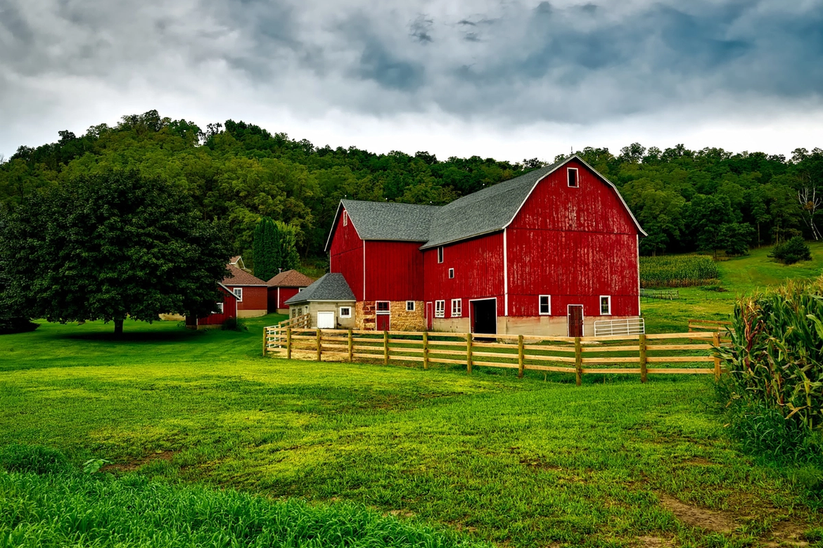 A red US style barn and farmhouse on a farm.