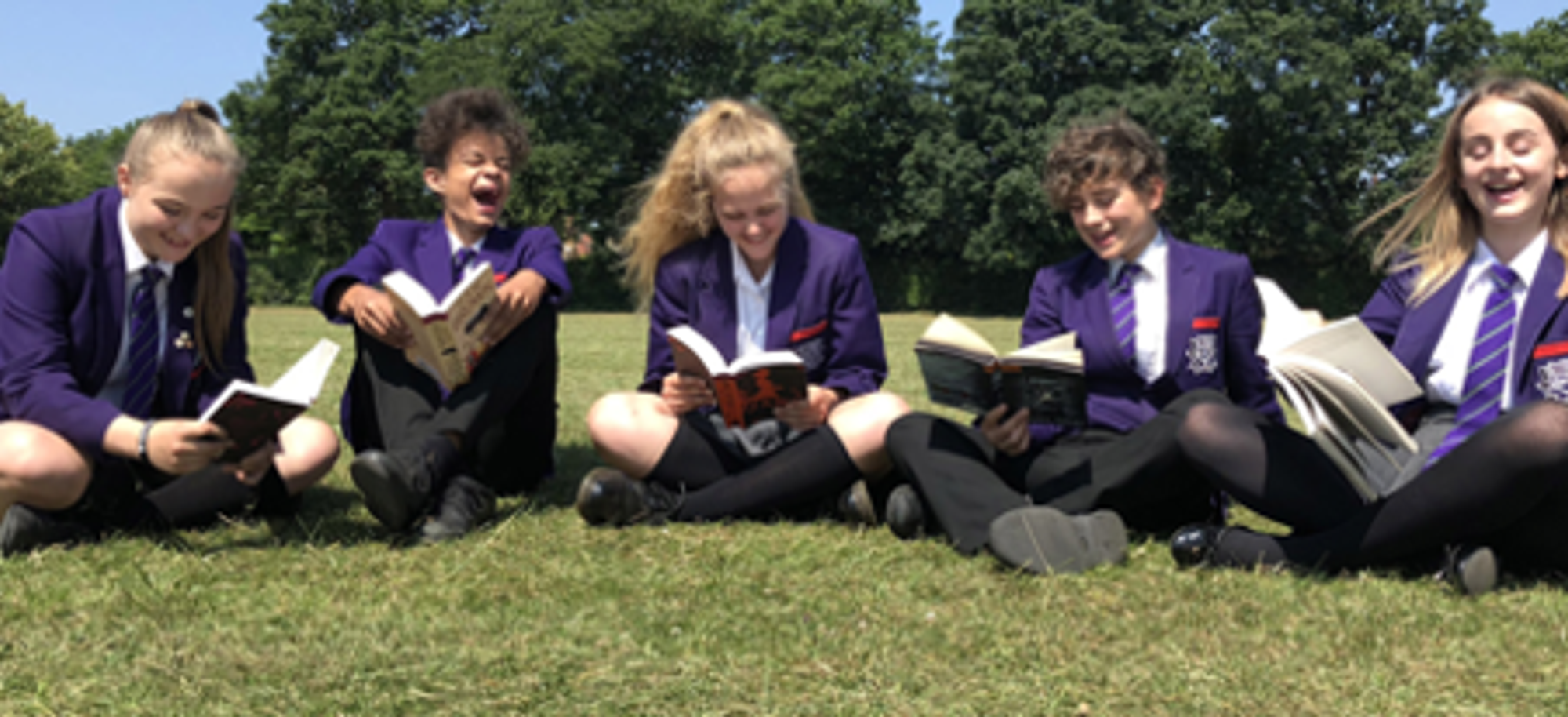 Learners at Alderbrook School reading on the grass