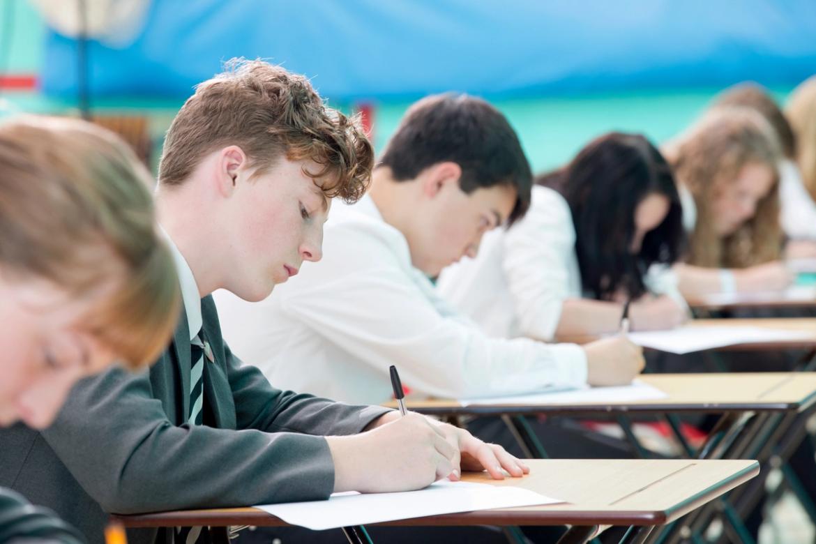 Secondary school children sitting in a hall taking a test