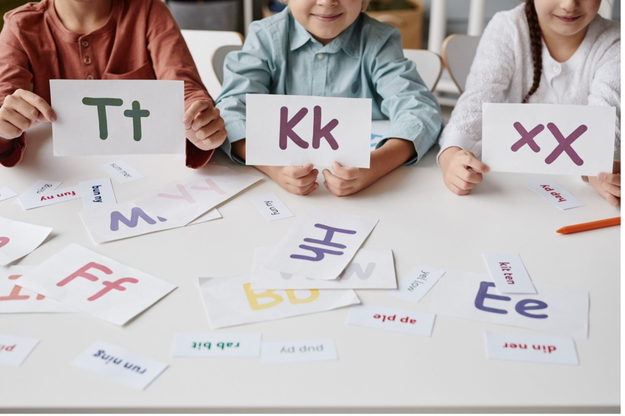 Students holding coloured alphabet cards