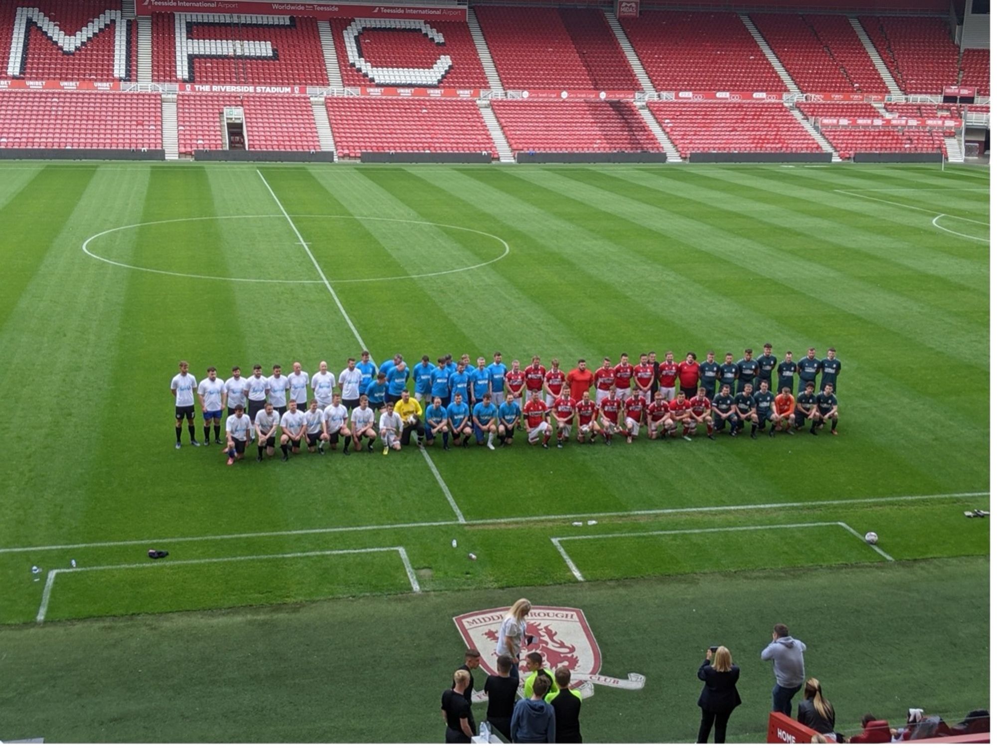 Middlesbrough football ground pitch with team lined up for photographs.