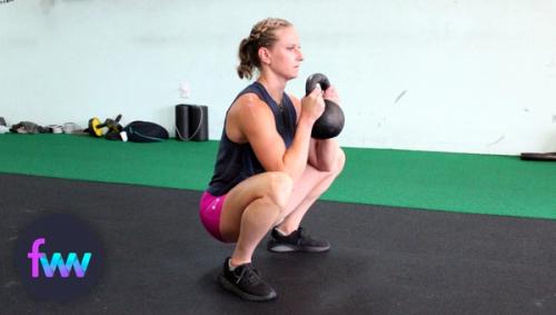 Kindal holding a squat with a kettlebell in goblet position.