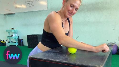 Kindal rolling the bottom of her forearm with a tennis ball.