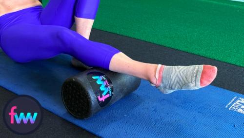 Kindal is foam rolling her calf to help warm them up and locate specific spots that are sensitive and ready for more attention.