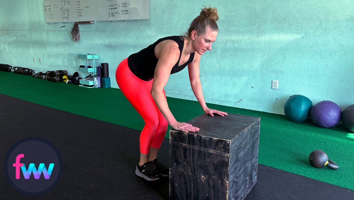 Kindal coming out of the pushup and jumping back in to jump up and complete the box burpee rep.
