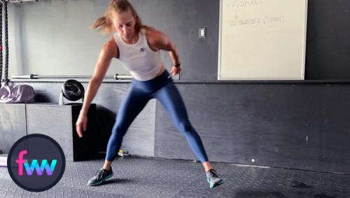 Kindal in the middle of the jump during a bodyweight skier exercise. She is working hard and pushing herself so that her workout time pays her back with results.